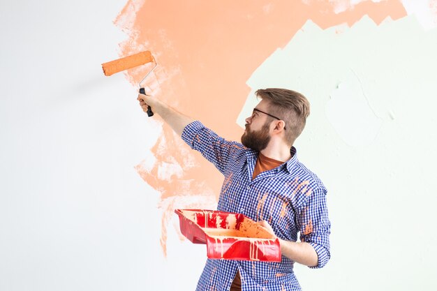 Ristrutturazione, ridecorazione e concetto di riparazione - muro dipinto ragazzo allegro nella nuova casa.