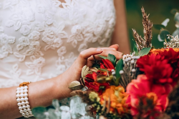 Ritaglia donna sfocata in abito da sposa bianco con bouquet vibrante incredibile e petali commoventi