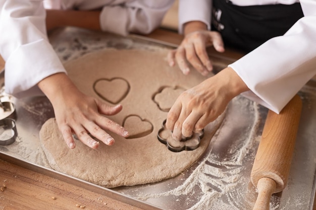 Ritaglia i bambini tagliando i biscotti dall'impasto