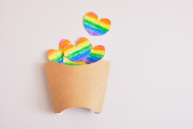 Ritaglia i cuori di carta colorati nella confezione per le patatine fritte, il concetto di orgoglio lgbt, il caffè per i rappresentanti della comunità lgbt