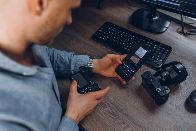 Ritaglia il colorista maschile con la fotocamera e il video di editing del telefono cellulare in ufficio a casa