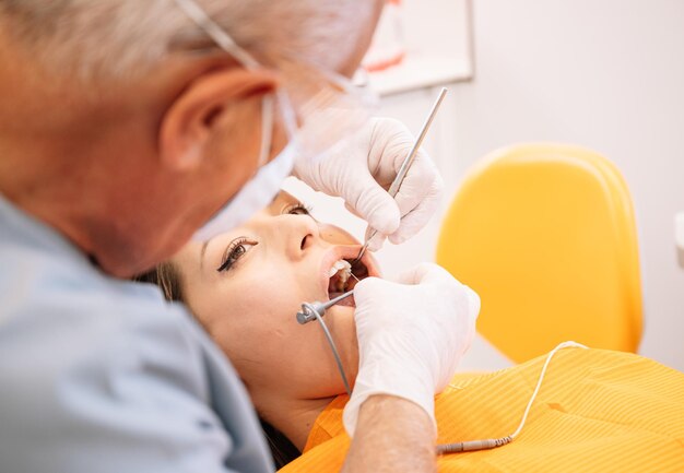 Ritaglia il dentista che inietta anestetico nelle gengive del paziente