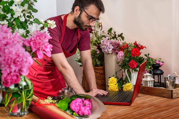 Ritagliare la vista sul saler dei fiori. Commercio floristico. Disposizione dei mazzi.