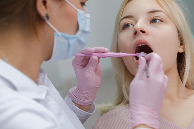 Ritagliata da vicino di una donna che ha esame dentale dal dentista