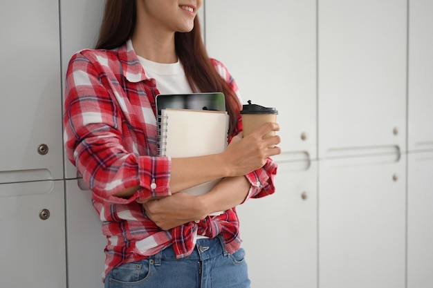 Ritagliata Studentessa universitaria asiatica attraente con la sua roba in piedi nello spogliatoio