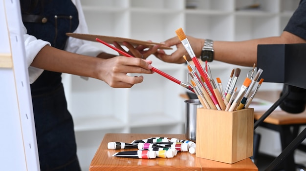 Ritagliato colpo due artisti che lavorano in studio d'arte.