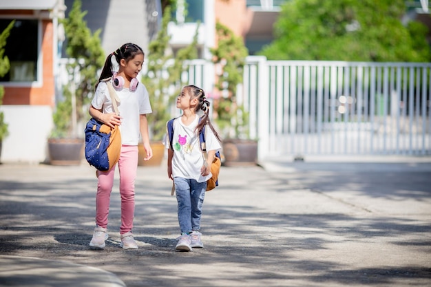 Ritorno a scuola Bambina asiatica carina con uno zaino che corre e va a scuola con divertimento