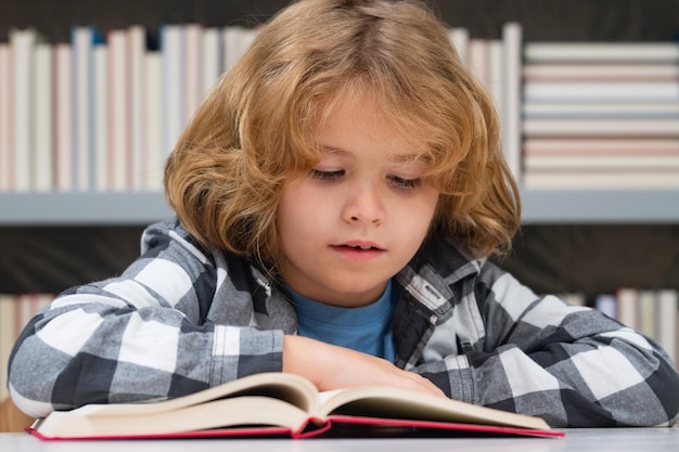 Ritorno a scuola Bambino che legge un libro rosso in biblioteca Piccolo studente sulla biblioteca della scuola