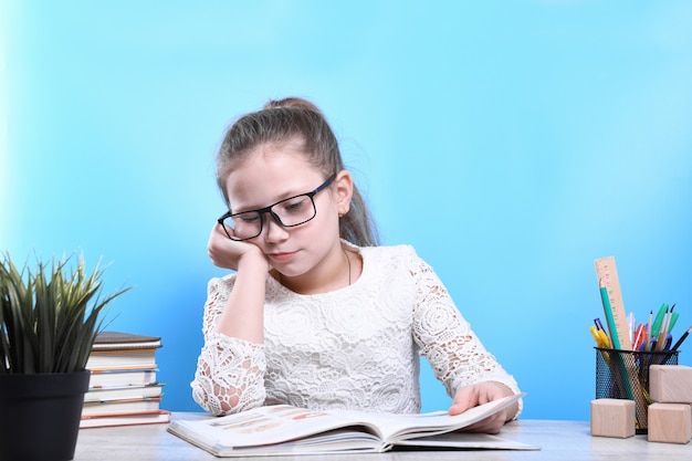 Ritorno a scuola. Felice carino bambino laborioso è seduto a una scrivania in casa. Il bambino sta imparando in classe.