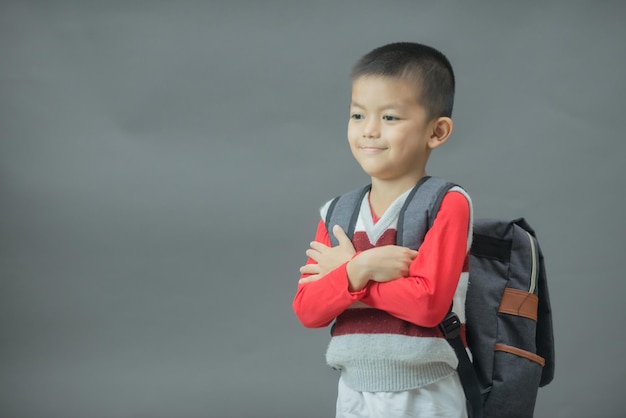 Ritorno a scuola Figura intera di un ragazzino divertente di 6 anni nello zaino con libri scolastici Bambino della scuola elementare con libro e borsa Istruzione