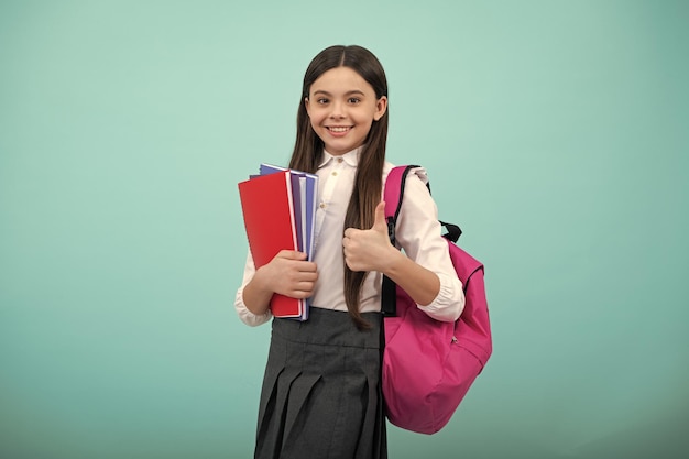 Ritorno a scuola La ragazza della scuola dell'adolescente tiene il libro e il quaderno pronti per imparare I bambini delle scuole con la borsa della scuola su sfondo blu isolato dello studio