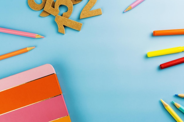 Ritorno a scuola Materiale scolastico su sfondo blu Accessori multicolori per bambini come pastelli forbici controller per videogiochi auricolare Spazio per il testo Vista dall'alto