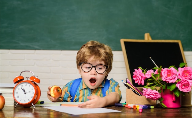 Ritorno a scuola ragazzo confuso in bicchieri lezioni di compiti a casa materie scolastiche concetto di educazione nerd