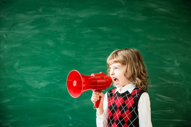 Ritorno a scuola Scolaro in classe Bambino felice contro la lavagna verde Educazione e creatività