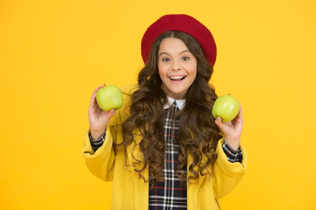 Ritorno a scuola spuntino Bambino felice tenere mele naturali sfondo giallo Promuovere cibo sano naturale a scuola Prodotti naturali a base di frutta Salute e nutrizione scolastica Sii intelligente mangia naturale