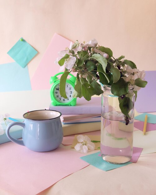 Ritorno a scuola, sveglia, bouquet di fiori di melo, pila di libri, tazza di tè