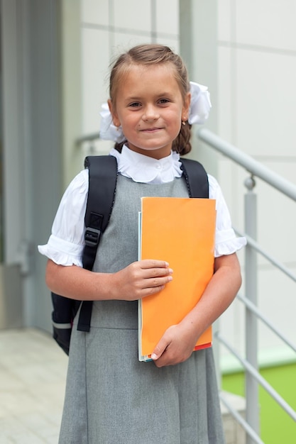 Ritorno a scuola un bambino laborioso con un libro il concetto di educazione tempo per lavorare sodo un piccolo studente intelligente 1 settembre una studentessa con una cartella nel cortile della scuola