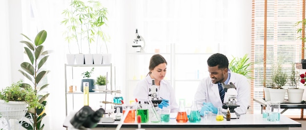 Ritratti di una varietà di scienziati che lavorano insieme in un laboratorio di ricerca Gruppo di studenti di chimica che lavorano in laboratorio con il microscopio e il liquido chimico nei bicchieri