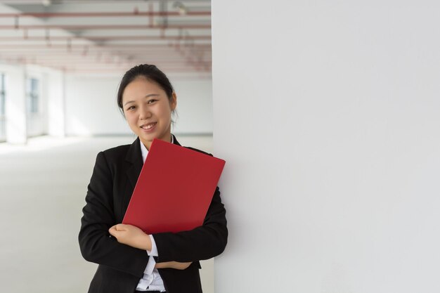 Ritratto a figura intera di giovani braccia femminili asiatiche incrociate e sorridente in piedi isolato su sfondo bianco