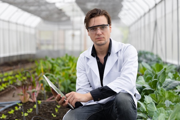 Ritratto agricoltura scienziato uomo pianta di lavoro ricerca in laboratorio bio fattoria studio biologo raccolta dati con computer portatile