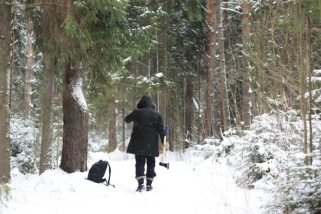 Ritratto all'aperto dell'uomo bello in cappotto e forfora. Uomo barbuto nei boschi invernali.