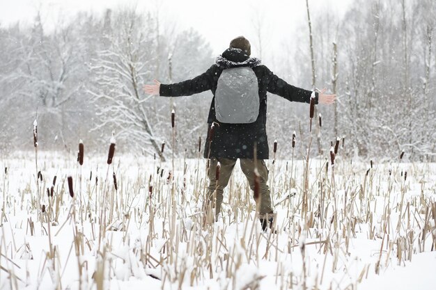 Ritratto all'aperto dell'uomo bello in cappotto e forfora. Uomo barbuto nei boschi invernali.