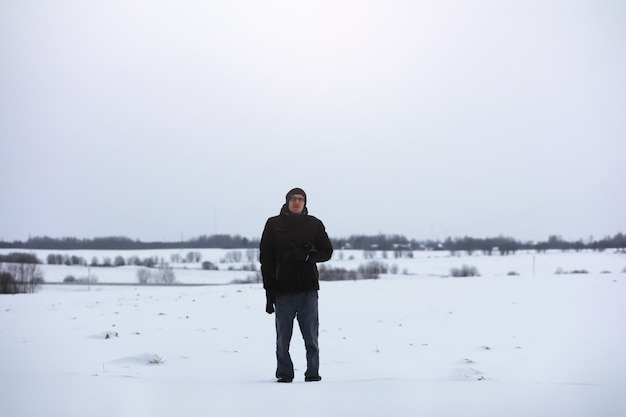 Ritratto all'aperto dell'uomo bello in cappotto e forfora. Uomo barbuto nei boschi invernali.