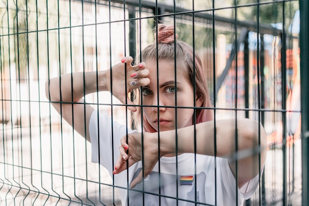 Ritratto all'aperto della ragazza giovane hipster hipster con capelli rosa e segno lgbt