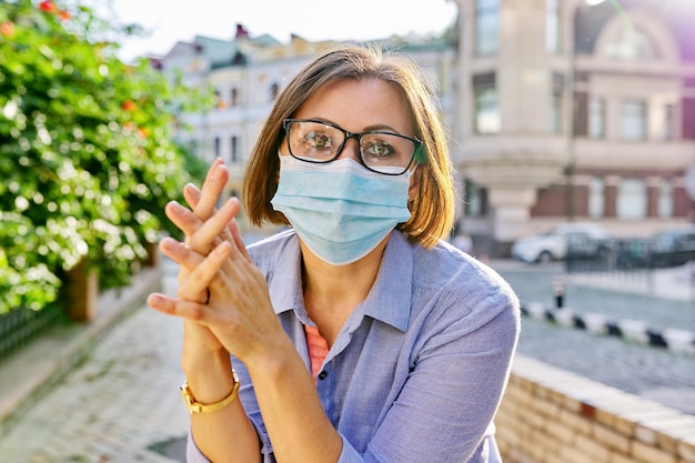 Ritratto all'aperto di donna matura d'affari in maschera protettiva medica con occhiali. Affari, pandemia, epidemia, assistenza sanitaria e medicina, stile di vita sano
