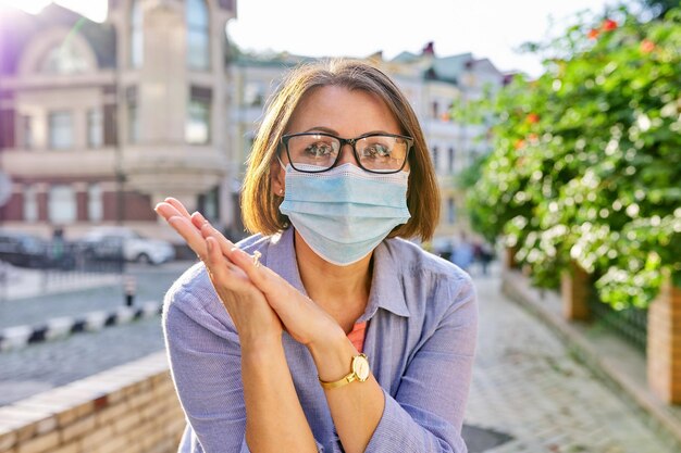 Ritratto all'aperto di donna matura d'affari in maschera protettiva medica con occhiali. Affari, pandemia, epidemia, assistenza sanitaria e medicina, stile di vita sano