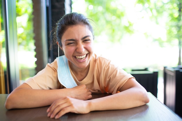 Ritratto all'aperto di una bella femmina castana indiana adulta sorridente e ridente