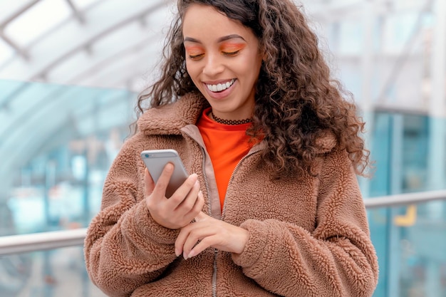 Ritratto all'aperto di una donna felice che parla al telefono in una città autunnale in Inghilterra