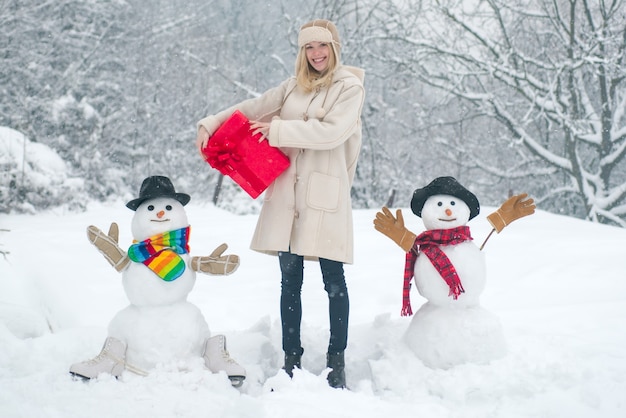 Ritratto all'aperto di una ragazza invernale con regalo in un clima invernale freddo e soleggiato nel parco amore invernale