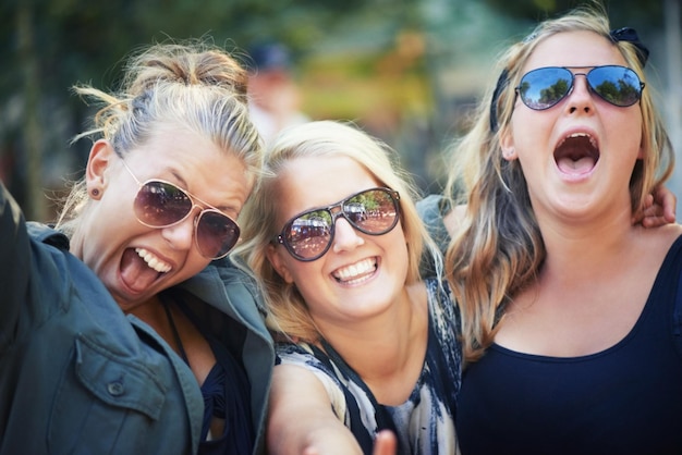 Ritratto all'aperto e donne con festival musicali, balli e natura con felicità, sorriso e allegria Affronta persone e amici con occhiali da sole, concerto ed energia con cultura, ambiente e gioia