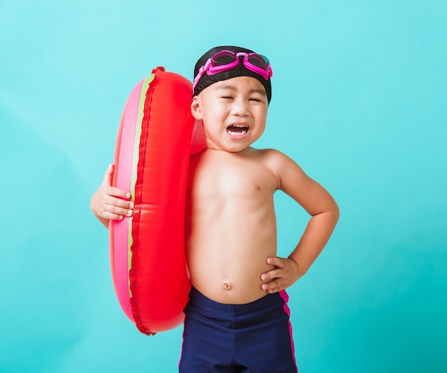 Ritratto asiatico felice bambino ragazzo indossa occhiali di protezione e costume da bagno tenere anello gonfiabile anguria Kid divertirsi in vacanza estiva