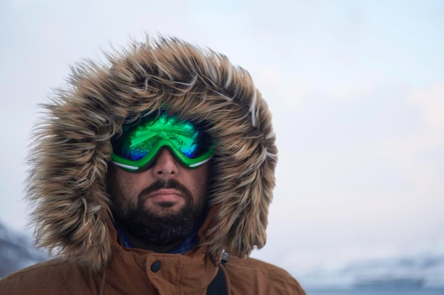 ritratto autentico uomo eschimese locale in inverno in tempo tempestoso indossando una calda giacca di pelliccia