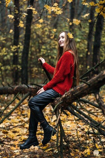 Ritratto autunnale di candida bella ragazza con foglie di caduta nei capelli Ritratto di donna felice in autunno