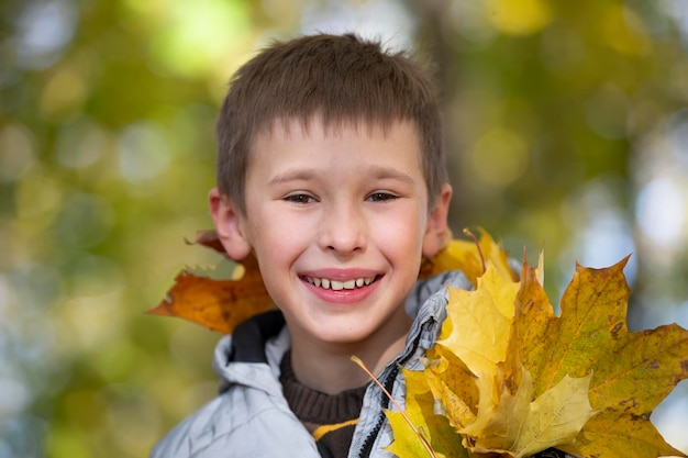 Ritratto autunnale di un bambino in foglie gialle autunnali