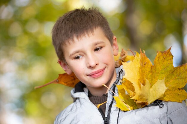 Ritratto autunnale di un bambino in foglie gialle autunnali