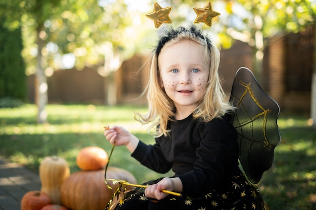 ritratto bambina bionda in costume di carnevale strega per halloween all'aria aperta