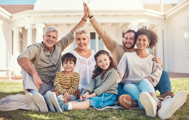 Ritratto batti il cinque e una famiglia nel giardino della loro casa insieme durante una visita con i nonni Diversità amore e figli con i genitori su un prato nel cortile per l'incollaggio in estate