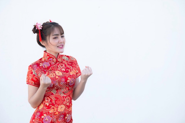 Ritratto bella donna asiatica in abito Cheongsam su sfondo biancoThailandia personeFelice anno nuovo cinese concettoFelice signora asiatica in abito tradizionale cinese