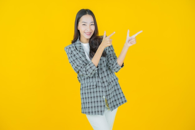 Ritratto bella giovane donna asiatica sorriso con azione su sfondo a colori