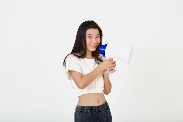 Ritratto bella giovane donna asiatica sorriso con megafono che fa annuncio in studio isolato