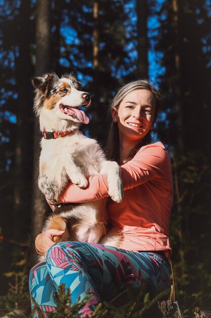 Ritratto candido di un'atleta con il suo compagno di corsa e escursione un cane pastore australiano