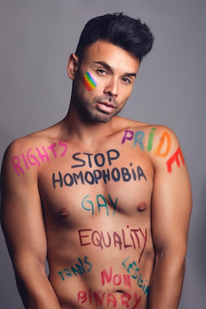 Ritratto creativo di un uomo gay con messaggi di protesta sul petto