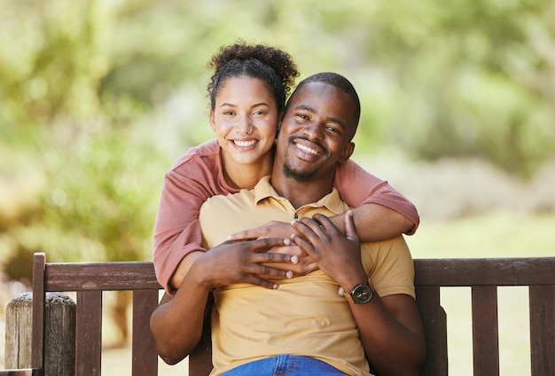 Ritratto d'amore e abbraccio di coppia in un giardino felice e sorridi mentre sei seduto rilassati e lega nella natura Affronta la famiglia nera e l'uomo con la donna in un parco tempo di qualità e goditi una giornata tranquilla in Messico