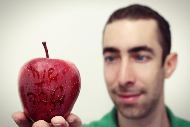 Ritratto da vicino di un uomo sorridente che tiene in mano una frutta