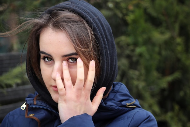 Ritratto da vicino di una bella giovane donna con la mano sul viso