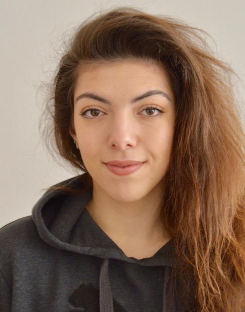 Ritratto da vicino di una bella giovane donna su uno sfondo beige